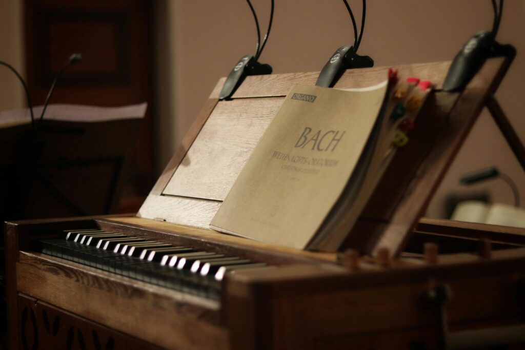 Close-up of a classic wooden organ with an open Bach music sheet, evoking nostalgia and history.
